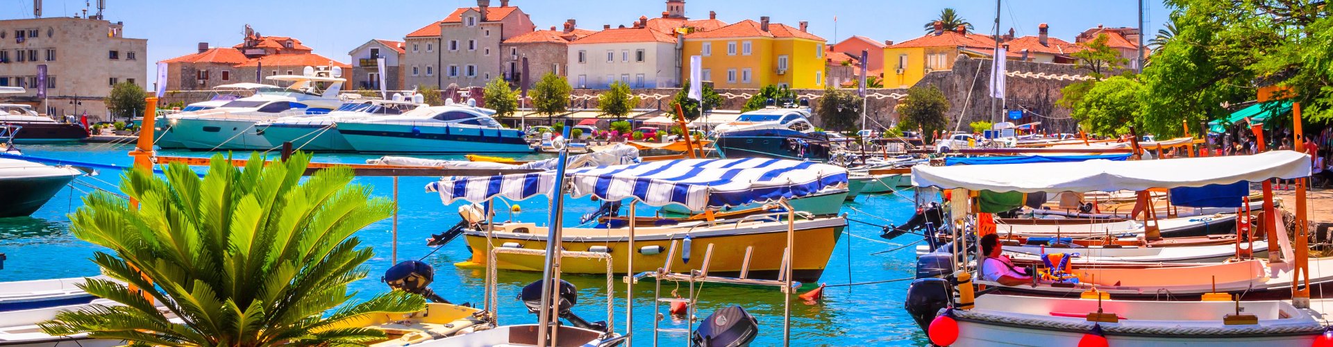 Night tram crossing cobblestone street in Budva