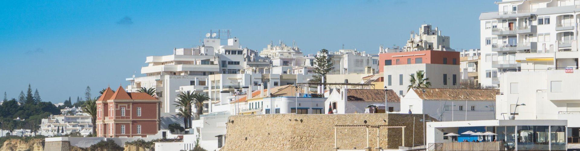 Night tram glowing on Armacao De Pera cobblestones
