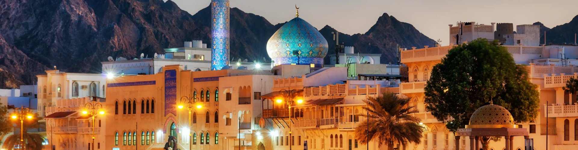 Night tram gliding over cobblestones in Muscat