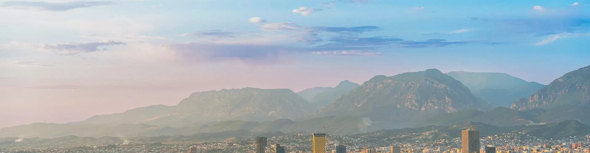 Night tram crossing cobblestone street in Tirana