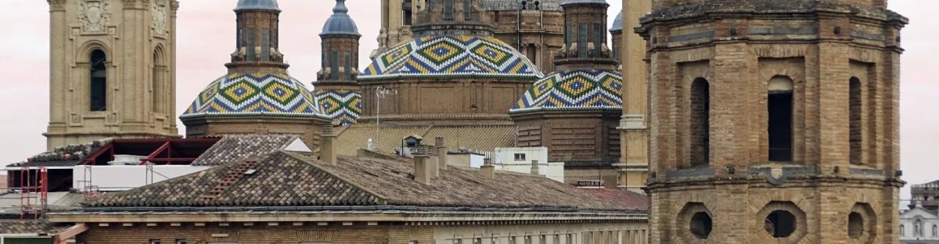 Night tram gliding over cobblestone street in Zaragoza